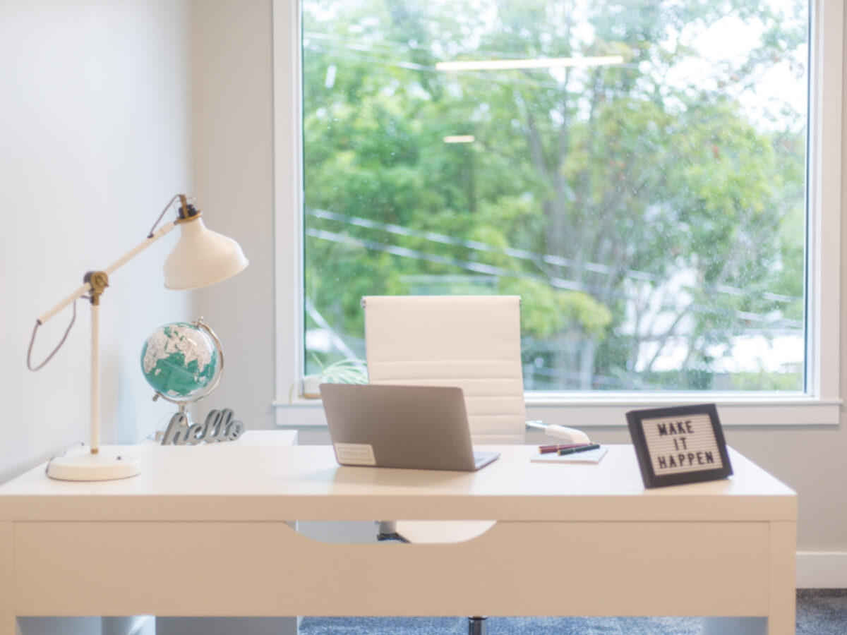 Un ordinateur portable sur un bureau clair, près d'une fenêtre