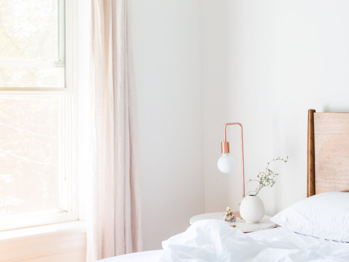 Une chambre claire, le lit fait et le linge blanc