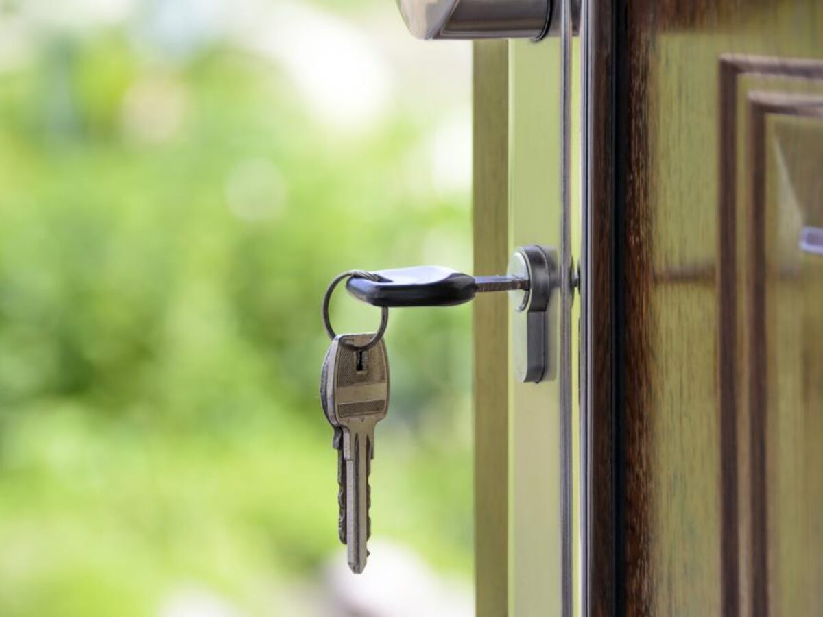 Un trousseau de clés dans la serrure d'une porte d'entrée